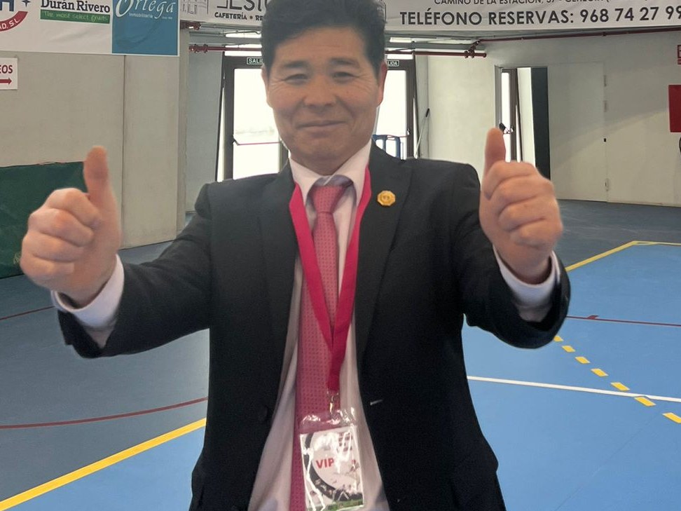 El maestro Yun, 9º Dan de Taekwondo, junto a la bandera de Corea
